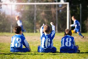 Young teammates sitting at the field